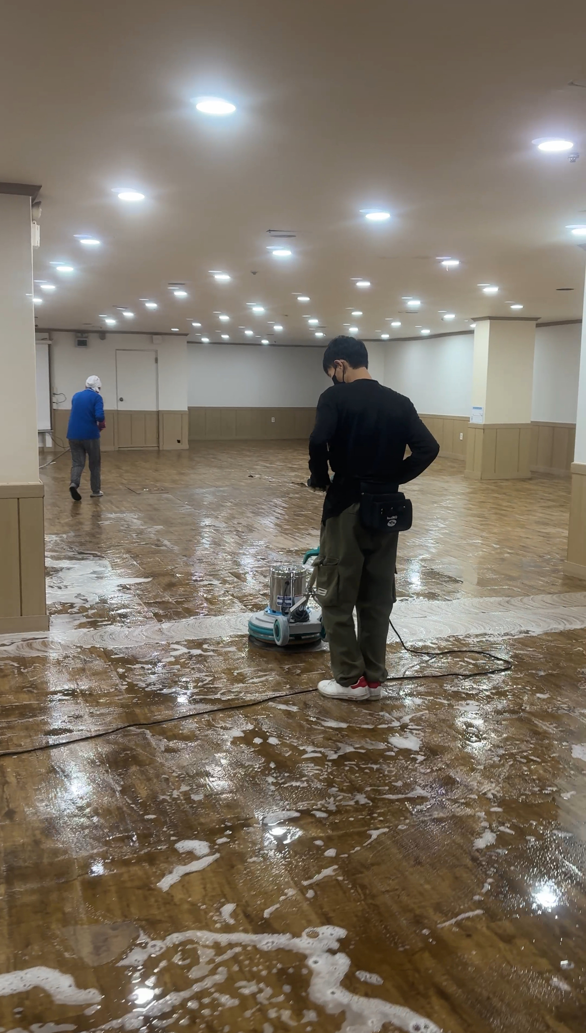 전문 장비로 공공시설 바닥을 청소하는 작업자
